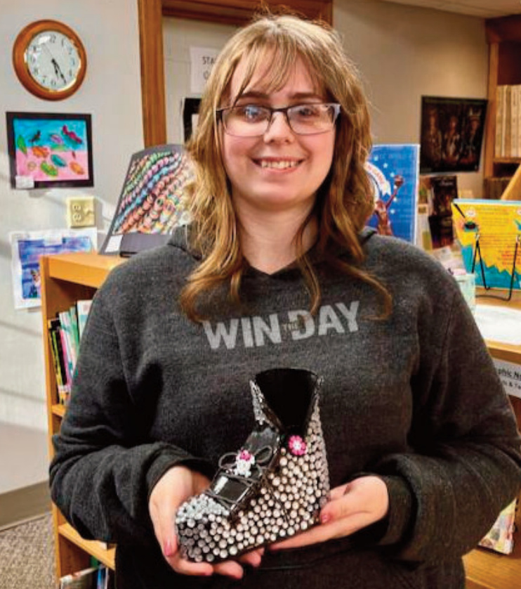 Argyle High School student Kie created a mixed-media sculpture titled Monster High after studying how art is used in design. Crafted from clay and embellished with gems and other decorative elements, the work takes the form of a boot inspired by one she would have liked to wear in grade school. Using themes in Monster High stories, Kie built her concept around the ideas of "glitter, fashion, friendship, and being empowered to be who you are." A serendipitous find - a skull-and-crossbones ornament - became a focal point on the front of the boot, adding to the ideas of "acceptance and uniqueness." Kie hopes to continue her artistic practice and pursue a future career in art and art education.