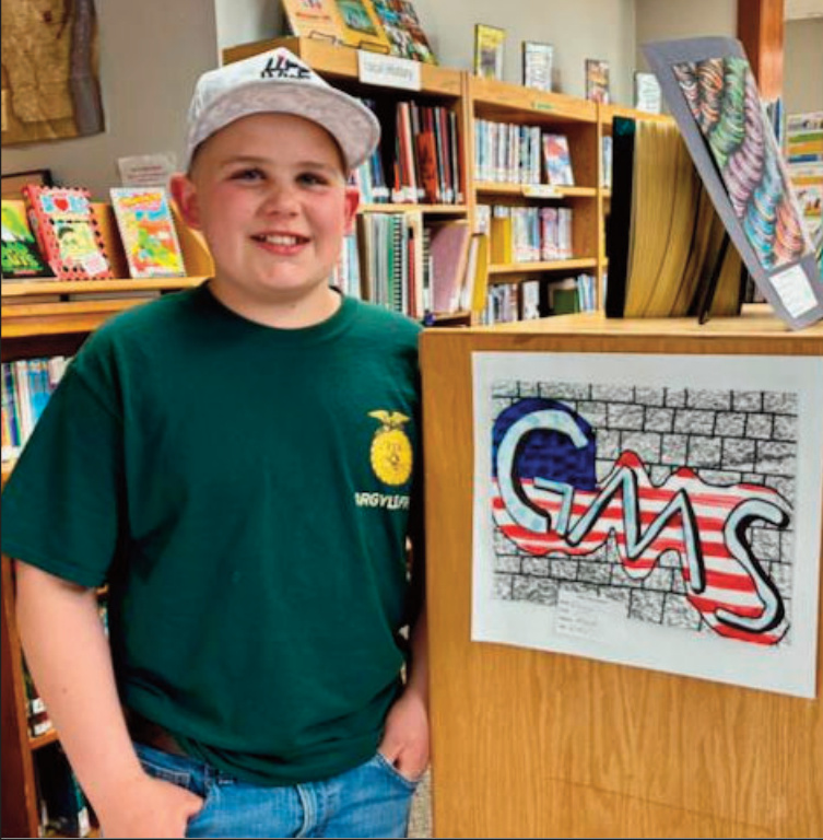Fifth-grader Gauge turned his initials into a piece of street art for his assignment. He explained that street art, unlike graffiti, is created with permission - an important distinction. Gauge built the design in layers, starting with shadows to give the letters depth, then adding an outline to make them stand out. He then added a brick wall background, using the classroom wall to add texture - and then an American flag. Outside the classroom, Gauge enjoys drawing pictures of farm equipment, a subject that reflects his creativity and personal interests.