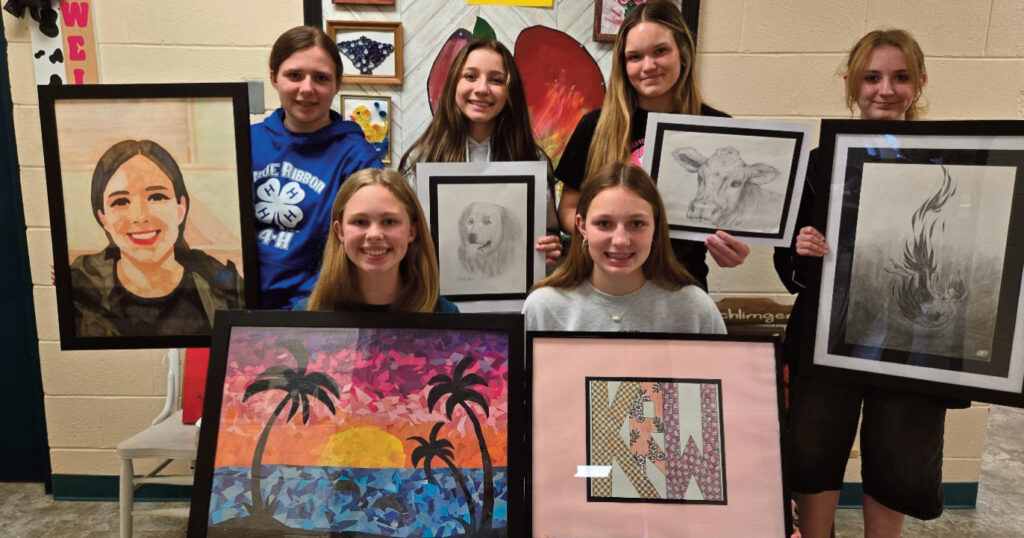 Photo of students holding their art pieces