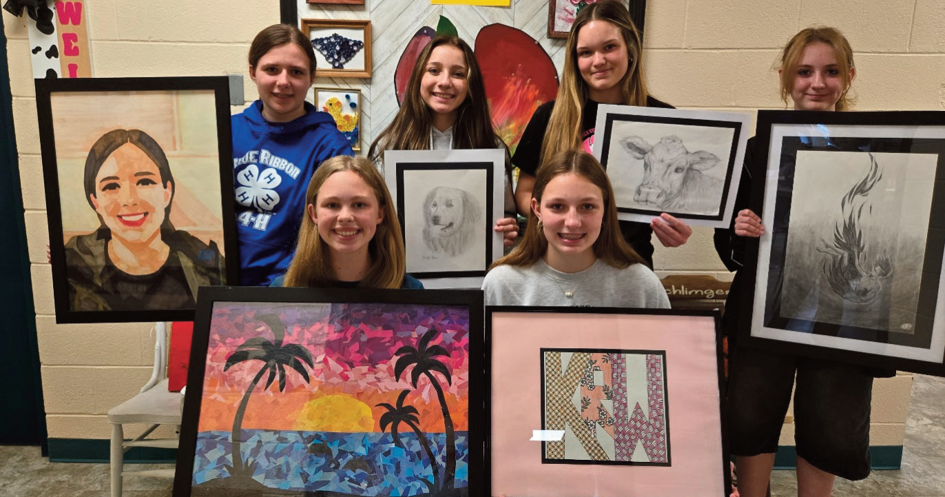 Photo of students holding their art pieces