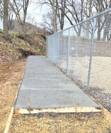 The sidewalk around the outer edge of the pond