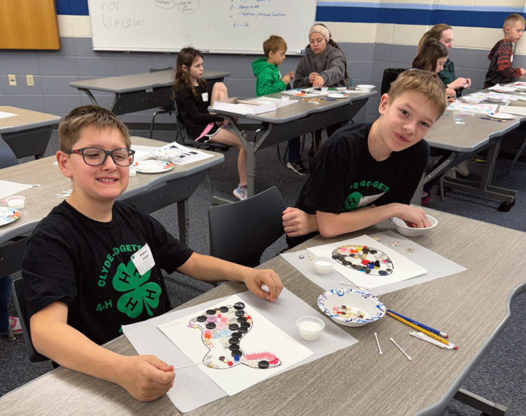 Jackson and Robert Prem of the Clyde Go Getters 4-H Club, work on their but- ton art project.