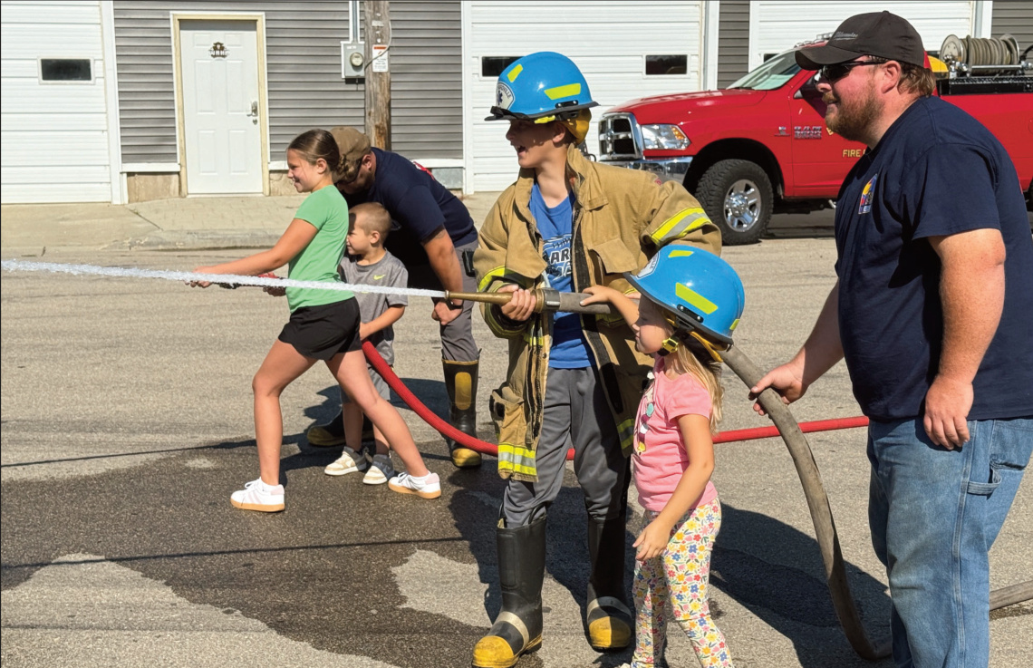 Paitin and Korbin Cullen (background) and Fred and Hannah Barnes (foreground) work together to fight a fire in a plywood house. Photo by Kayla Barnes.